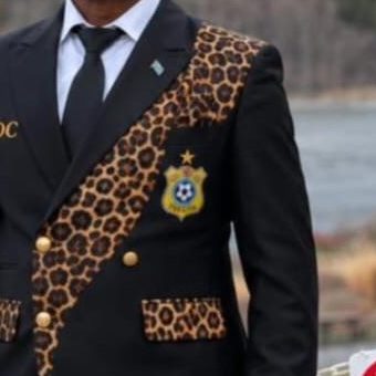Close-up of a black suit with braid trim and leopard-print panels