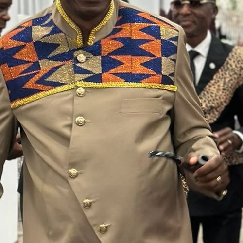 Close-up of a beige outfit with a kente bib